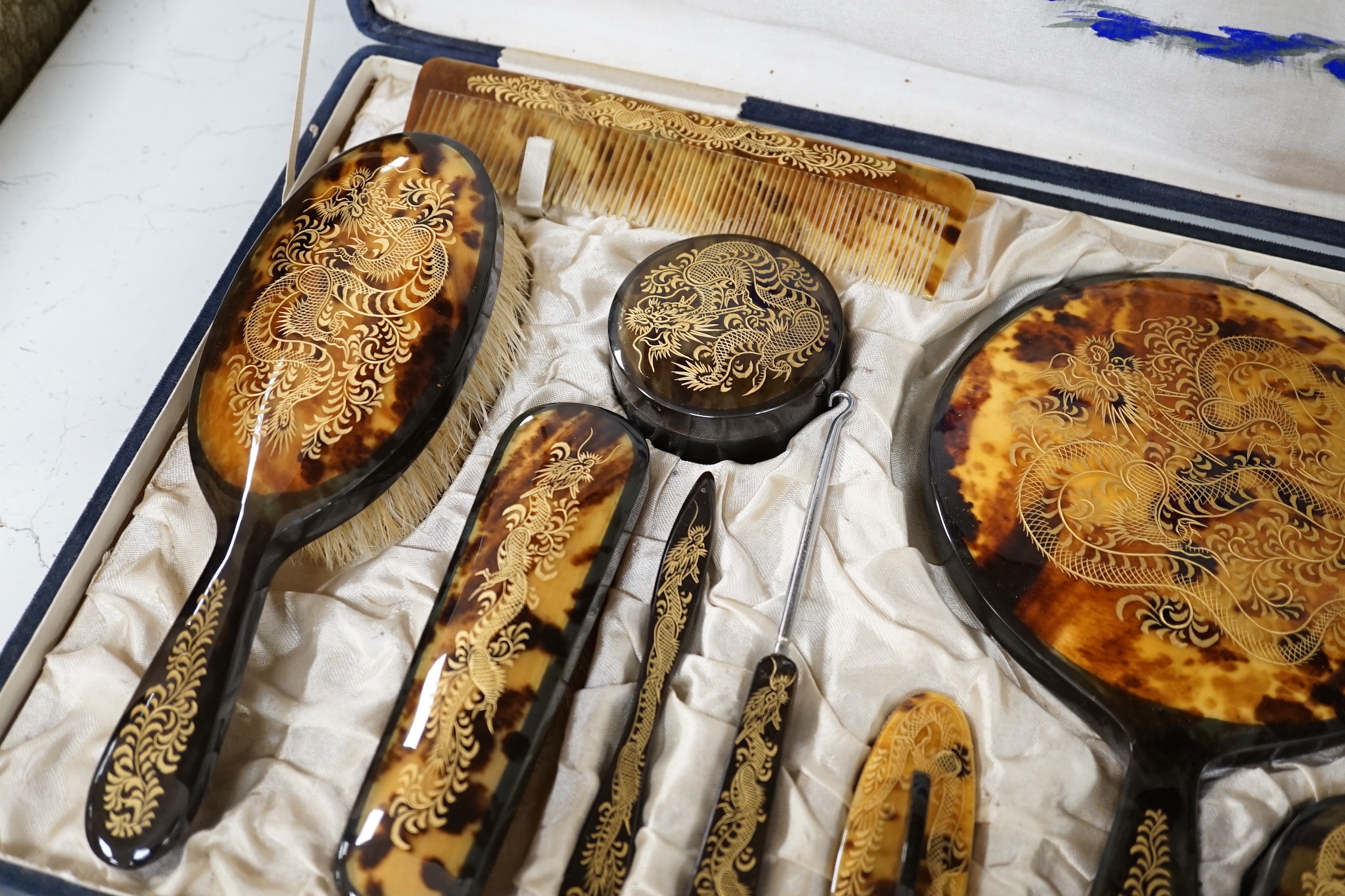 A cased Japanese tortoiseshell dragon decorated dressing table set, c.1940 (with original packing case sent from Hong Kong in 1940)